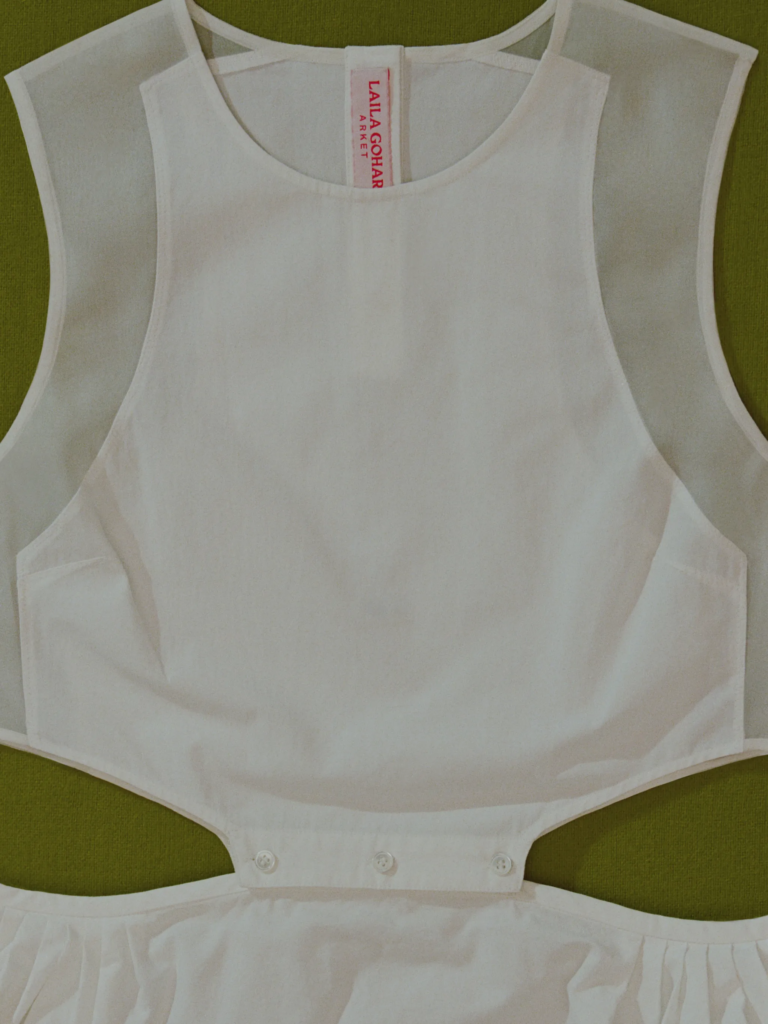 A Arket marca a estreia de Laila Gohar no prêt-à-porter com uma coleção de 27 peças para a primavera de 2026, disponível a partir de terça-feira nas lojas e online entre 25 e 229 euros. A linha explora o contraste entre masculino e feminino, transparente e opaco, em separates versáteis que incluem desde conjuntos canvas bordados até tops de seda organza em ecru.