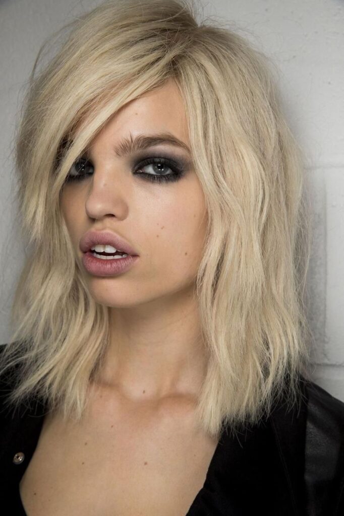 Cabelo messy com textura natural e maquiagem borrada inspirada nos anos 90
