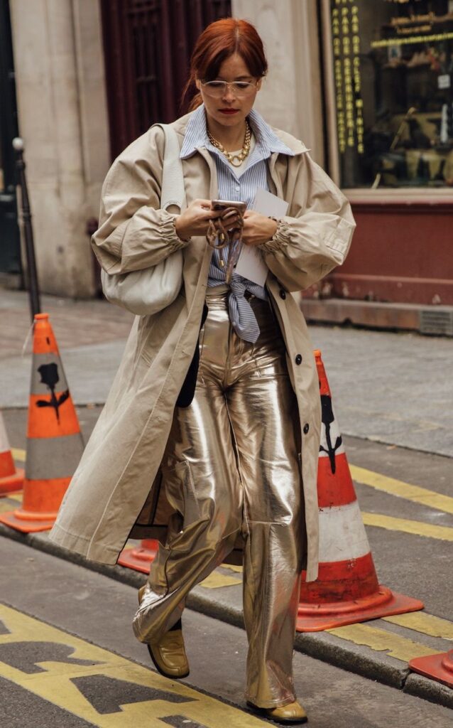 Calça metalizada combinada com trench coat neutro