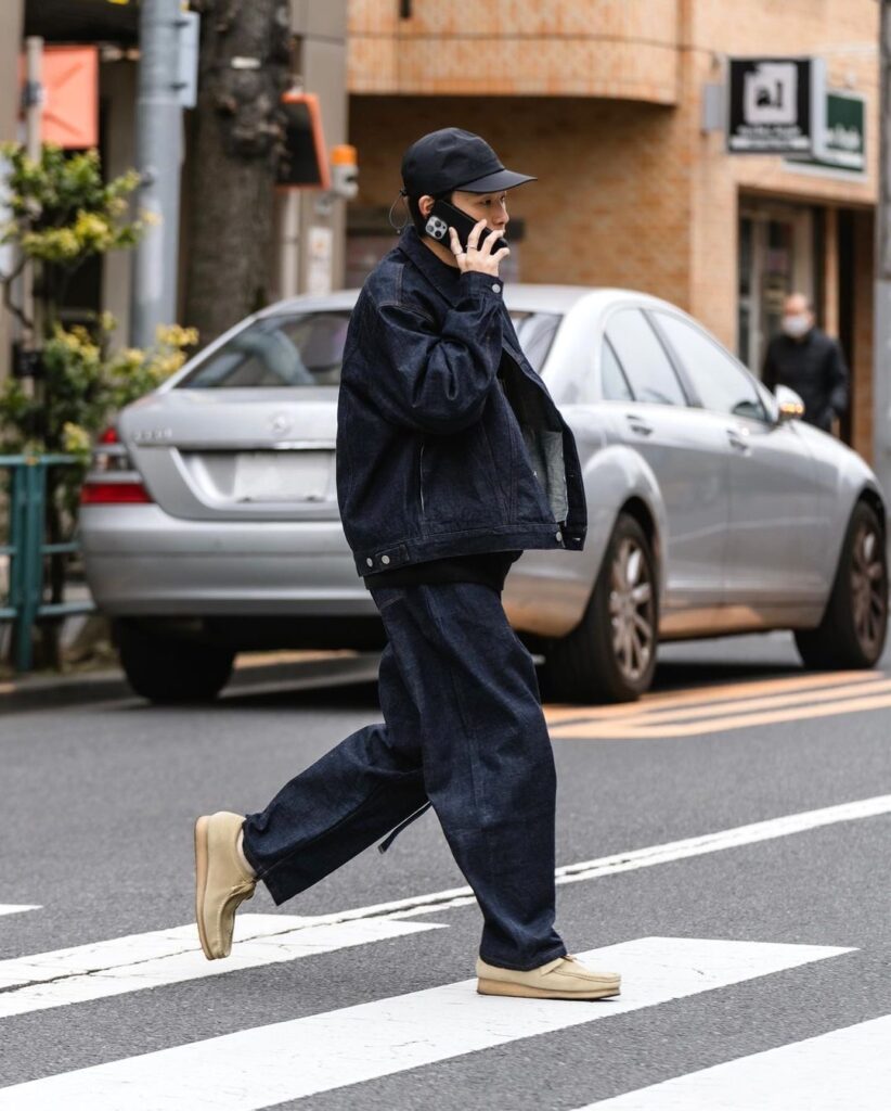Sapatos Clarks usados com jeans reto e camisa oversized em look urbano.