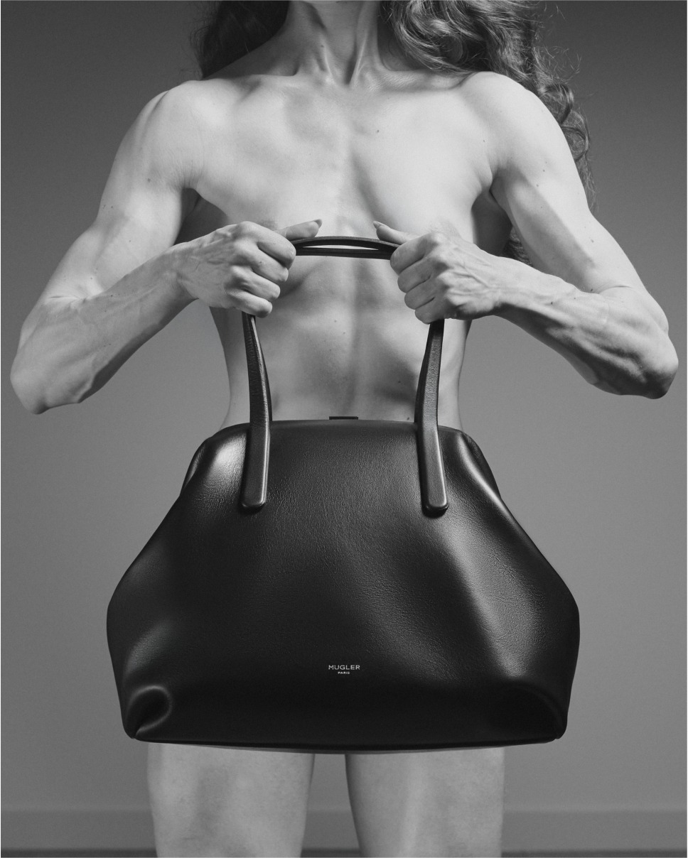 Costas musculosas de fisiculturista segurando a bolsa Lua City preta da Mugler